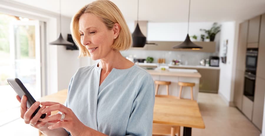 Woman with cell phone in a room filled with sunlight
